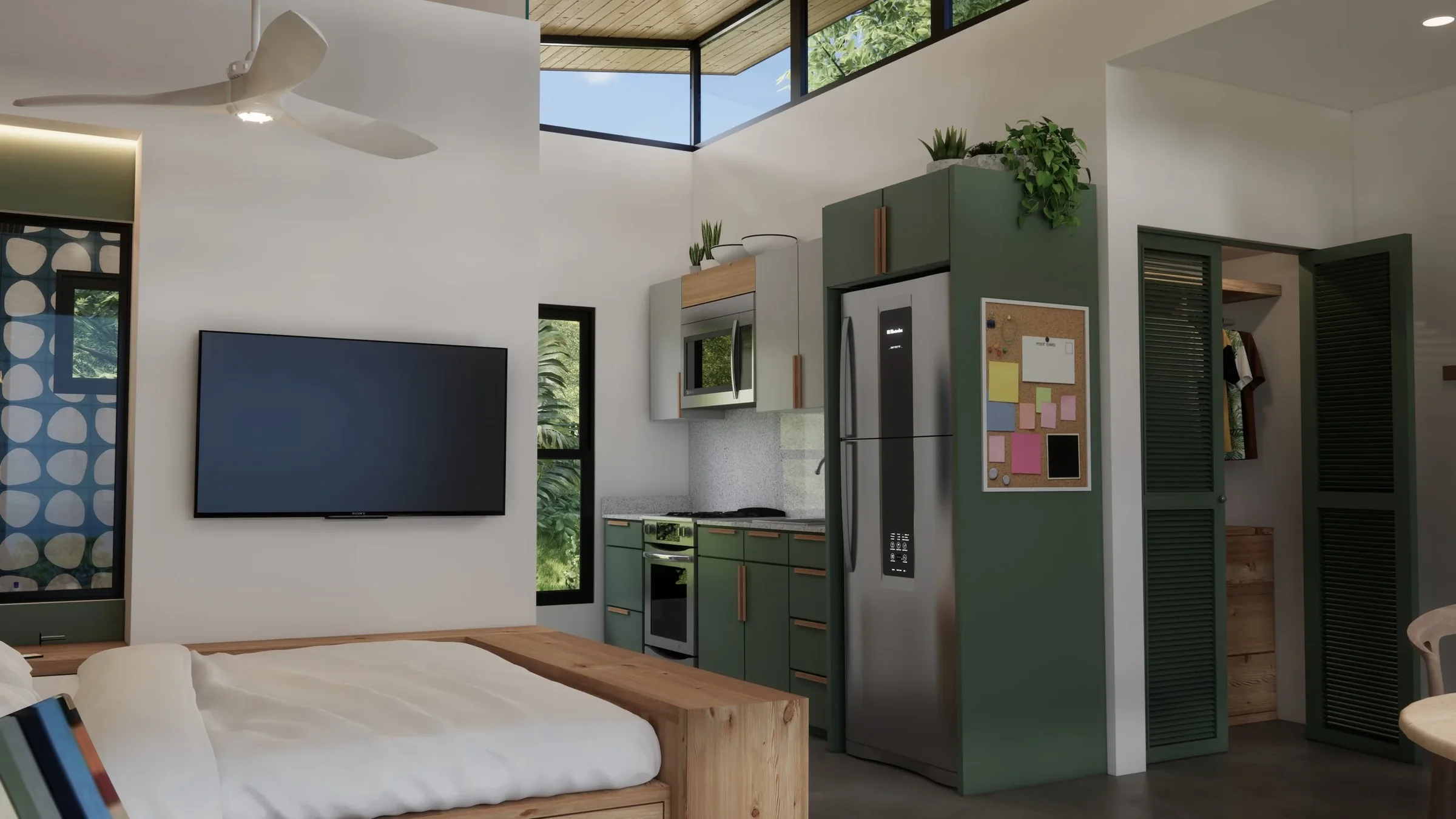 Interior of a modern compact living space with a bed, a wall-mounted TV, a small kitchen with green and beige cabinets, stainless steel appliances, and a closet with louvered doors, decorated with plants and a corkboard.