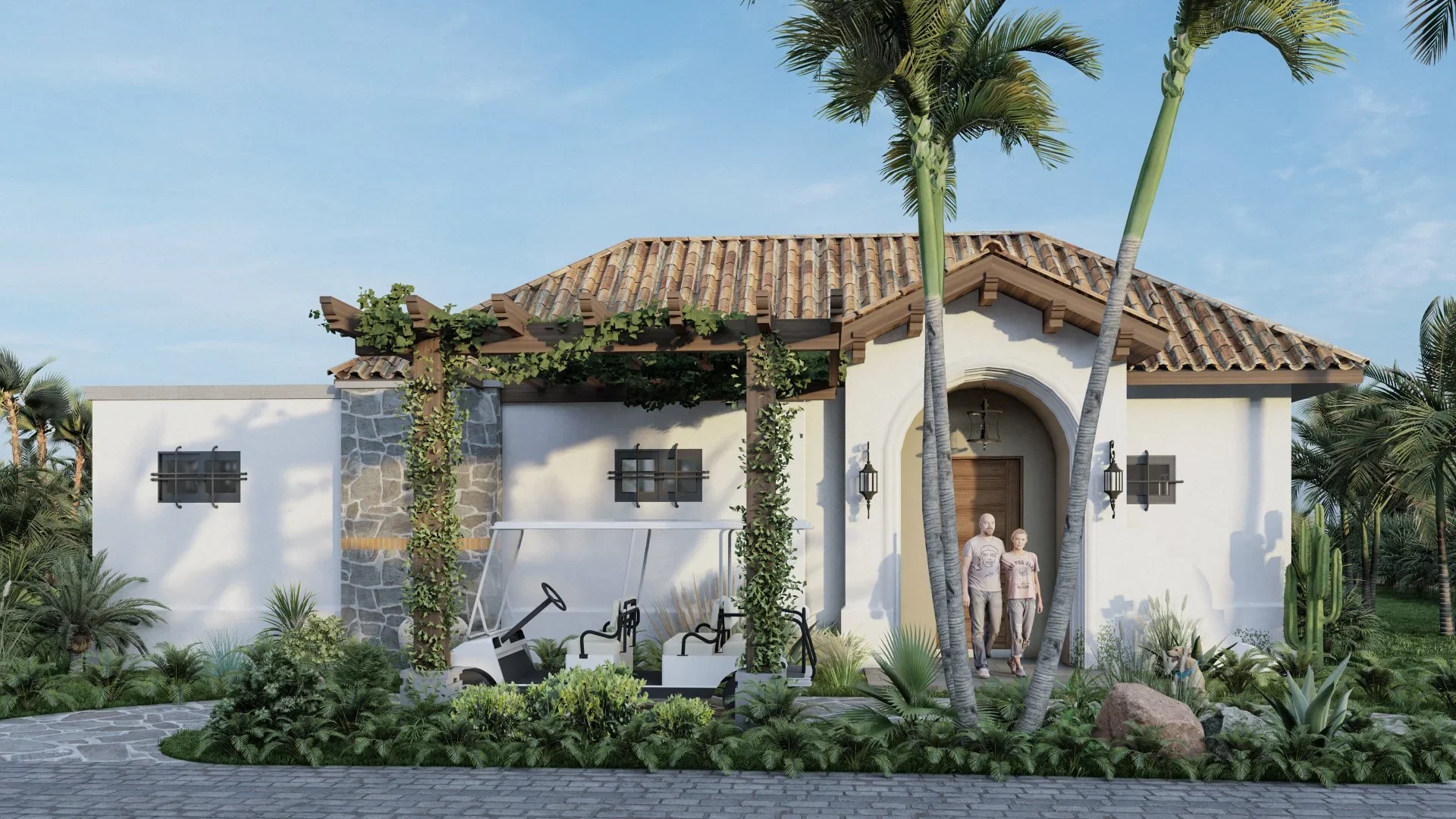 A house with a Spanish-style tiled roof, white walls, and decorative stone accents. There are two people walking out of the house, lush greenery including palm trees, cactus, and other plants around the house, and a paved driveway in the foreground.