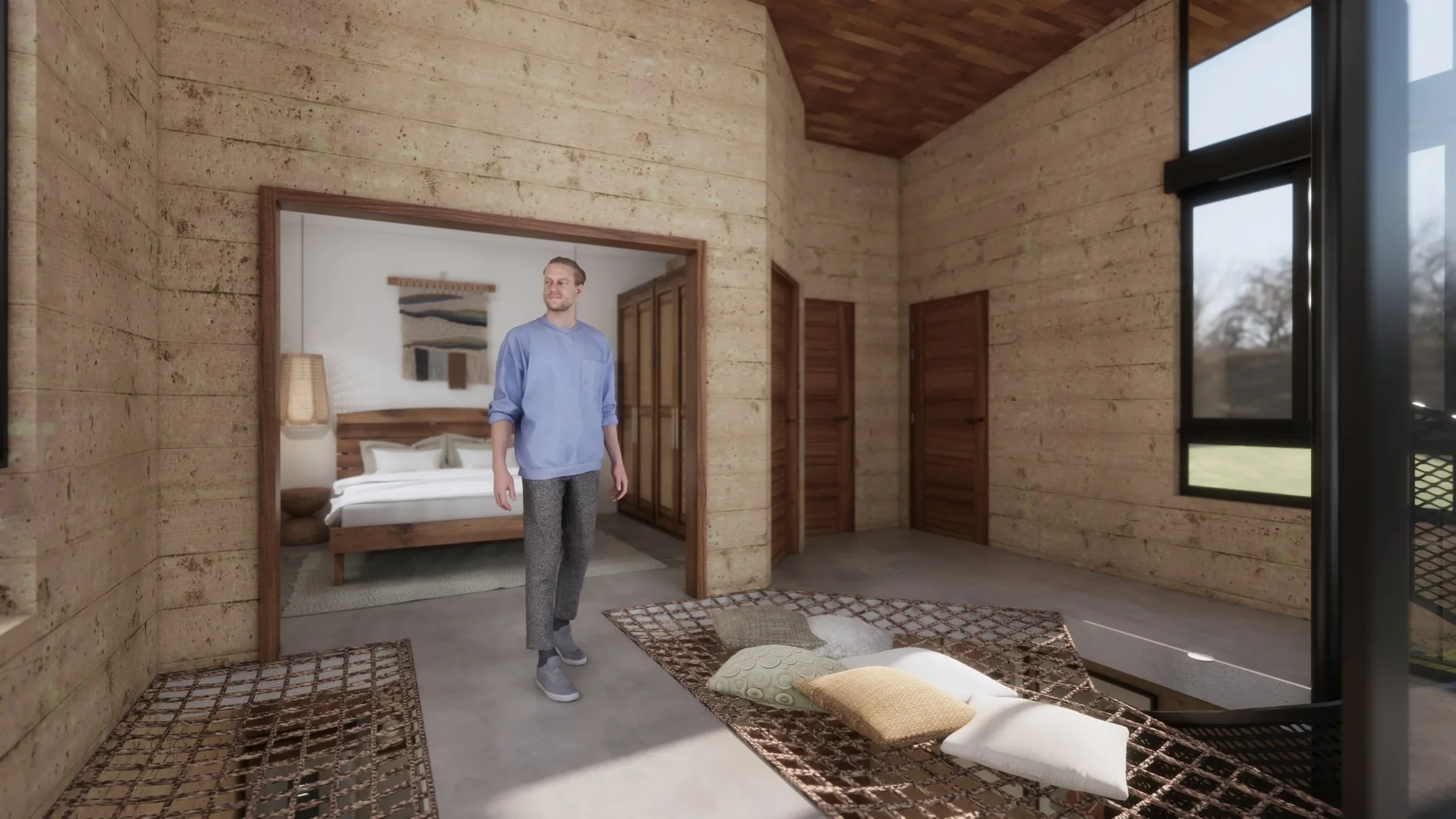 A man is standing in a rustic wooden room with large windows, inside a house or cabin. In the adjacent bedroom, there is a bed with white bedding, and a woven wall hanging. The room features wood panel walls, wooden sliding doors, and a patterned rug